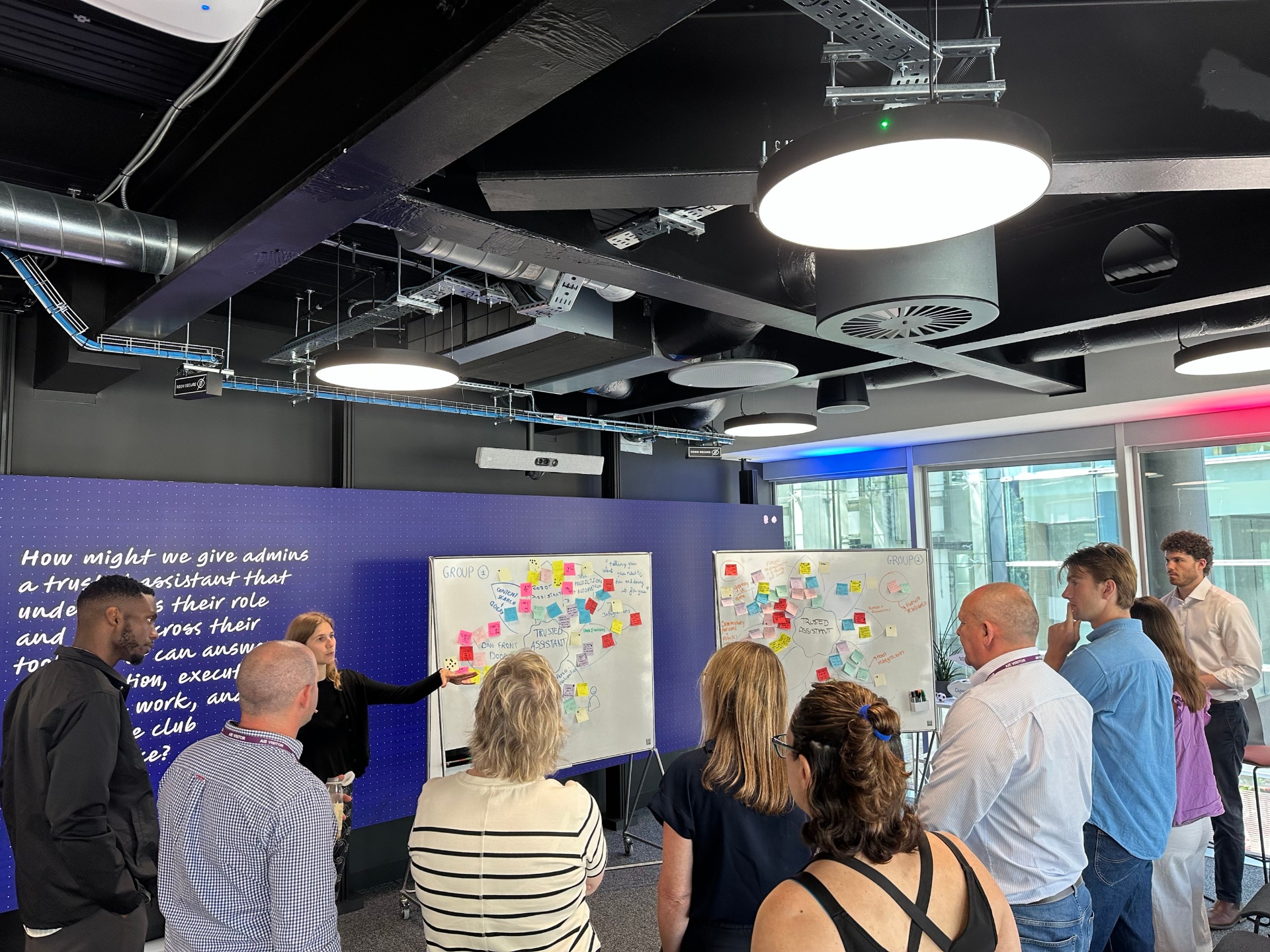 Facilitating a design workshop with stakeholders around whiteboards