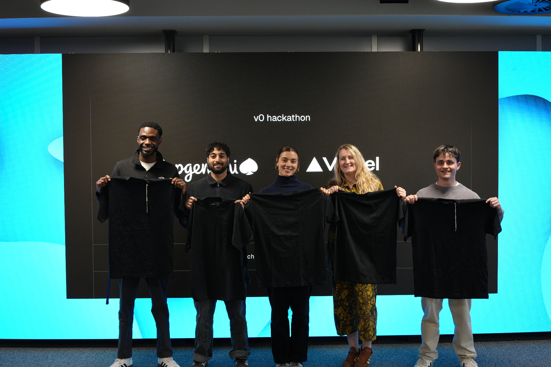 Team holding shirts on stage at the v0 hackathon